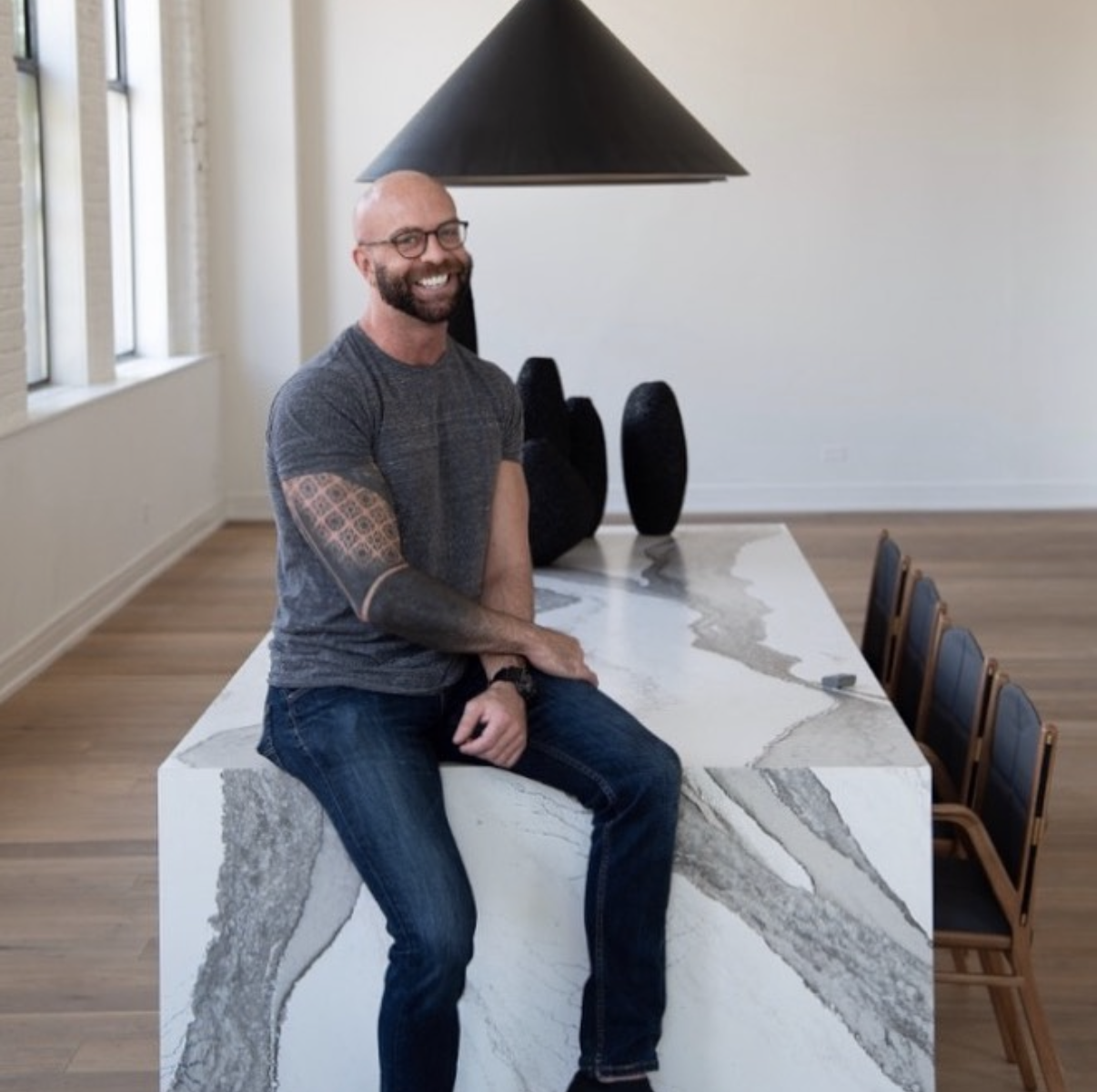 David smiling while sitting on a marble table